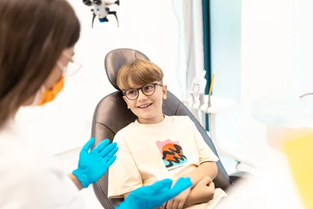 Dečak u stomatološkoj stolici sa doktorkom